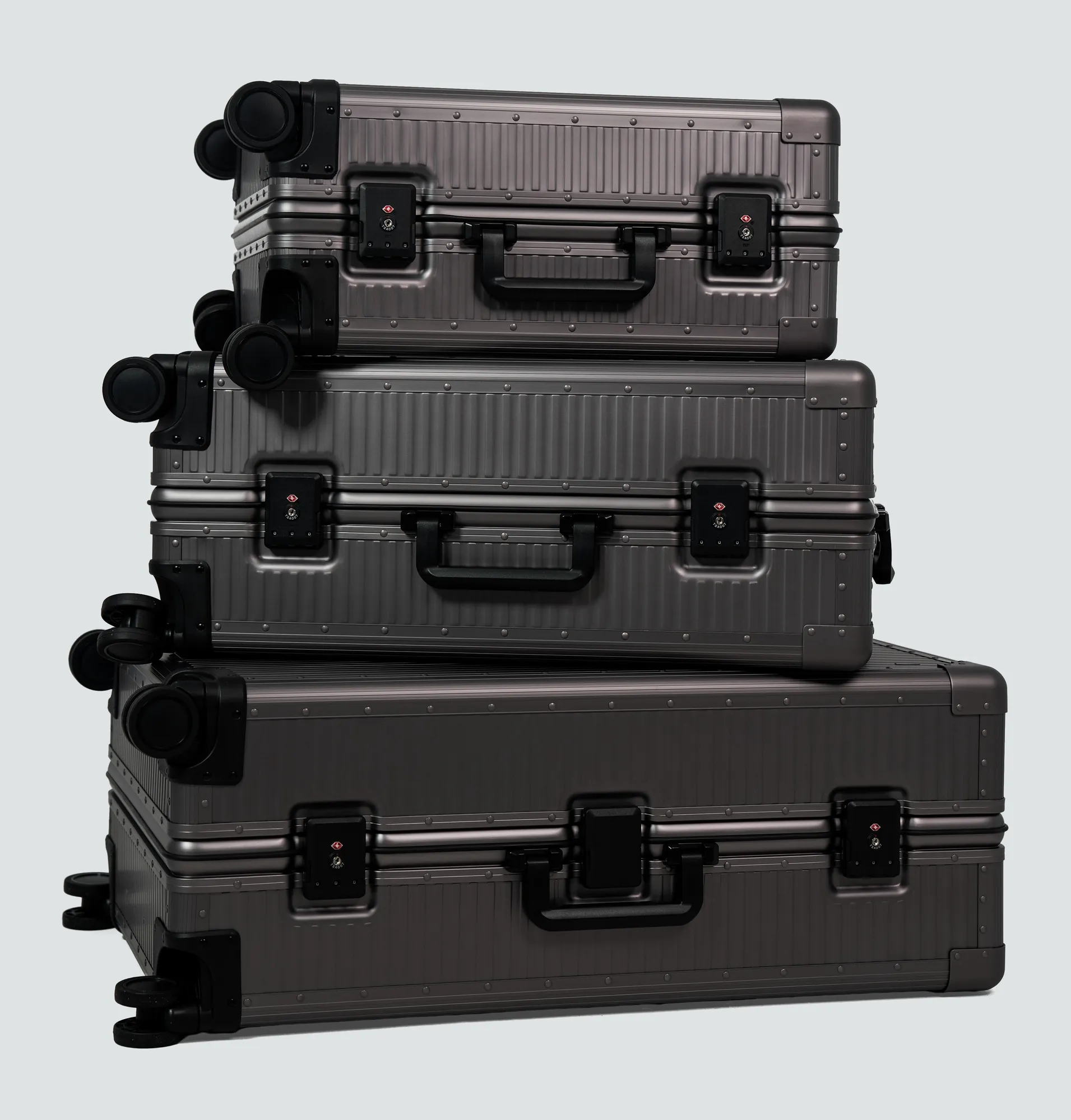 A stack of three high-end Loure travel suitcases demonstrating durability and premium materials