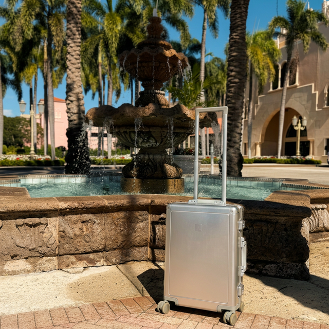 A luxury Loure travel suitcase sitting by a beautiful Miami beachfront